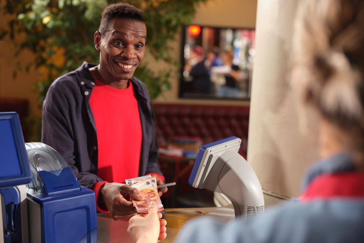 Client en train de payer en espèces chez son buraliste