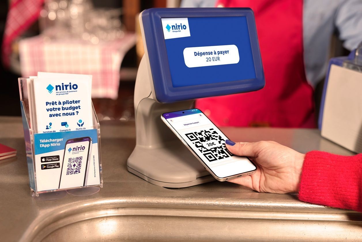 Utilisateur de l'application Nirio en train de montrer son QR code chez un buraliste